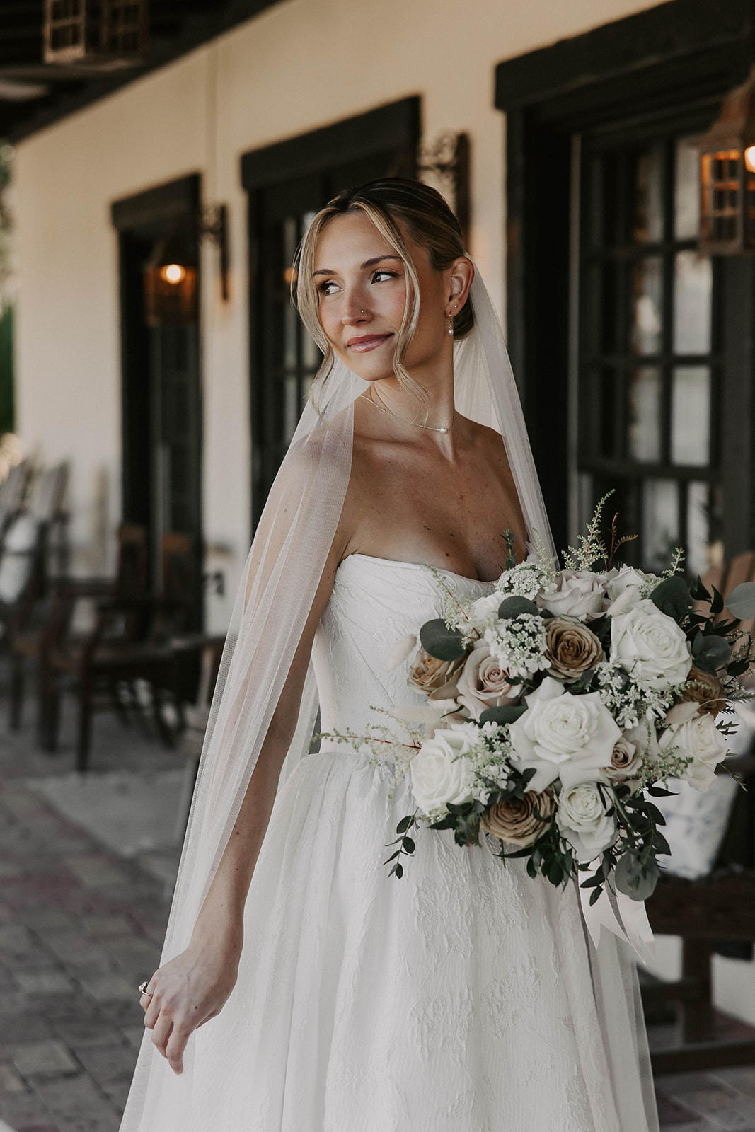 bridal portrait la hacienda snow hill brooksville florida - A Fall Wedding at La Hacienda on Snow Hill in Brooksville, FL Bride in a strapless lace wedding gown and flowing veil holding a lush bouquet of white and taupe roses with eucalyptus greenery at La Hacienda on Snow Hill wedding venue in Brooksville Florida near Tampa
