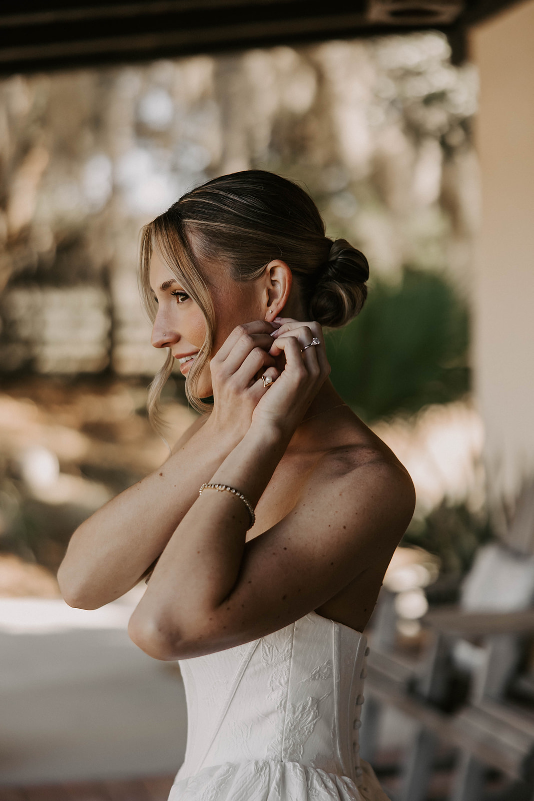bride putting on earring la hacienda brooksville florida - A Fall Wedding at La Hacienda on Snow Hill in Brooksville, FL Bride in a strapless white wedding gown putting on her earring while getting ready at La Hacienda on Snow Hill wedding venue in Brooksville Florida near Tampa