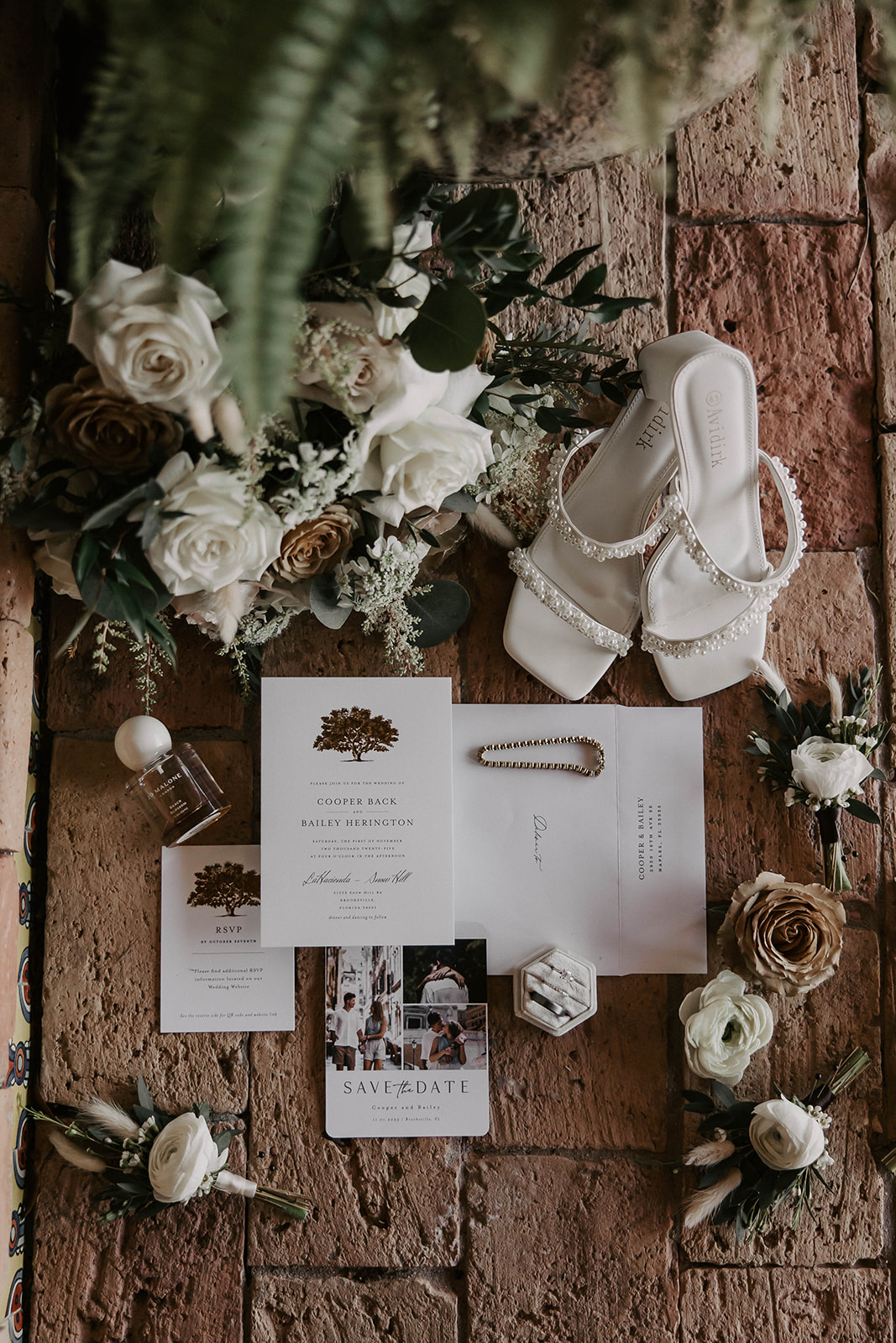wedding details flatlay la hacienda snow hill brooksville - A Fall Wedding at La Hacienda on Snow Hill in Brooksville, FL Wedding details flatlay featuring pearl bridal heels, white and neutral rose bouquet, ring box, perfume, and invitation suite for Cooper Back and Bailey Herington at La Hacienda on Snow Hill in Brooksville Florida
